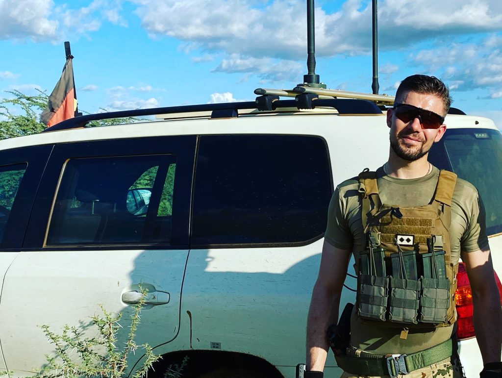 Erik Reifferscheid in Uniform vor einem Fahrzeug.